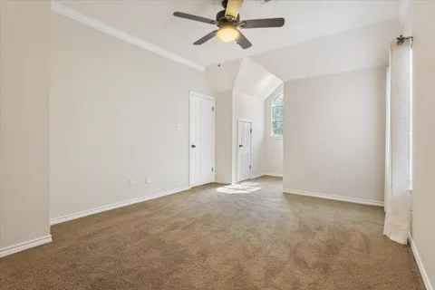 an empty room with chandelier fan