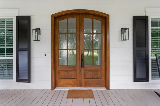 a view of an entryway with wooden floor door and a window