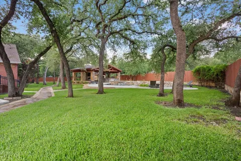 an aerial view of residential houses with outdoor space and trees