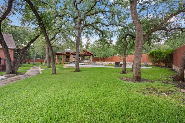 an aerial view of residential houses with outdoor space and trees