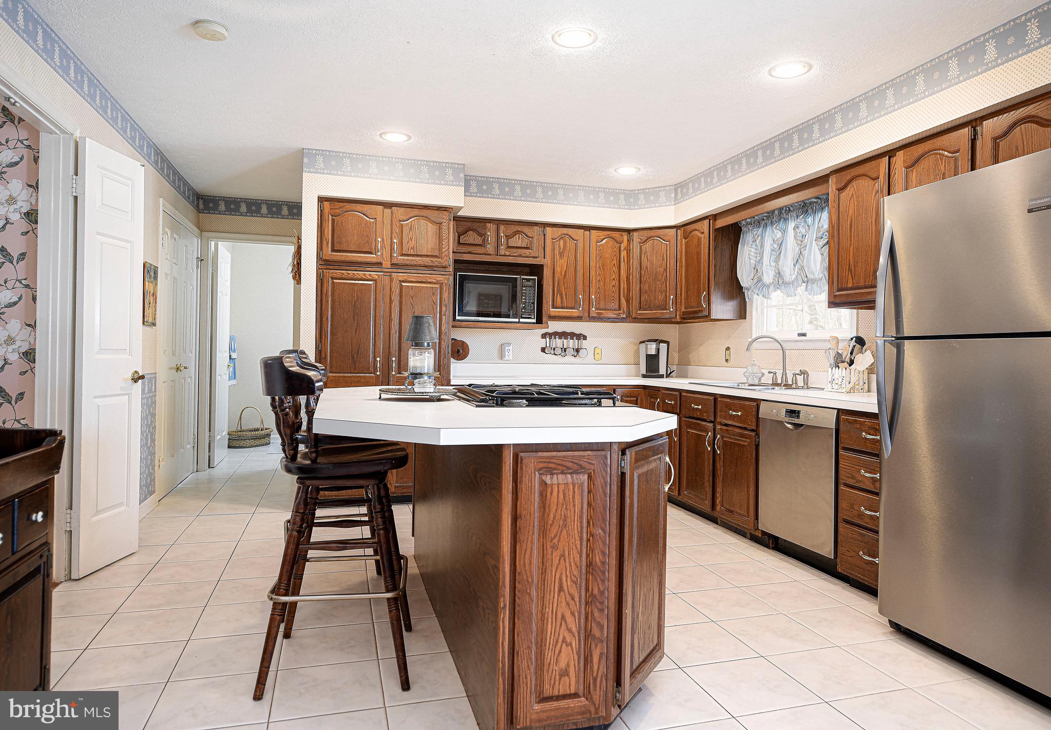 627 Northgate Road Aberdeen, MD 21001 - Photo 12 of 43 a kitchen with stainless steel appliances granite countertop a refrigerator a sink a stove a microwave and a dining table with wooden floor