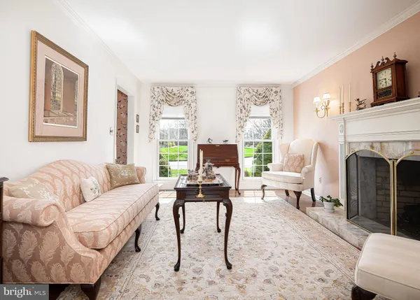 a living room with furniture a fireplace and a large window