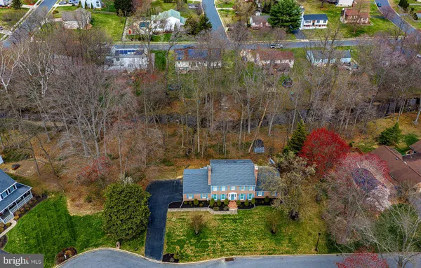 an aerial view of residential house with outdoor space and trees all around