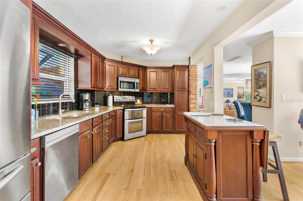 475 Guerrant Street Umatilla, FL 32784 - Photo 16 of 63 a kitchen with stainless steel appliances granite countertop a stove a sink dishwasher and a refrigerator