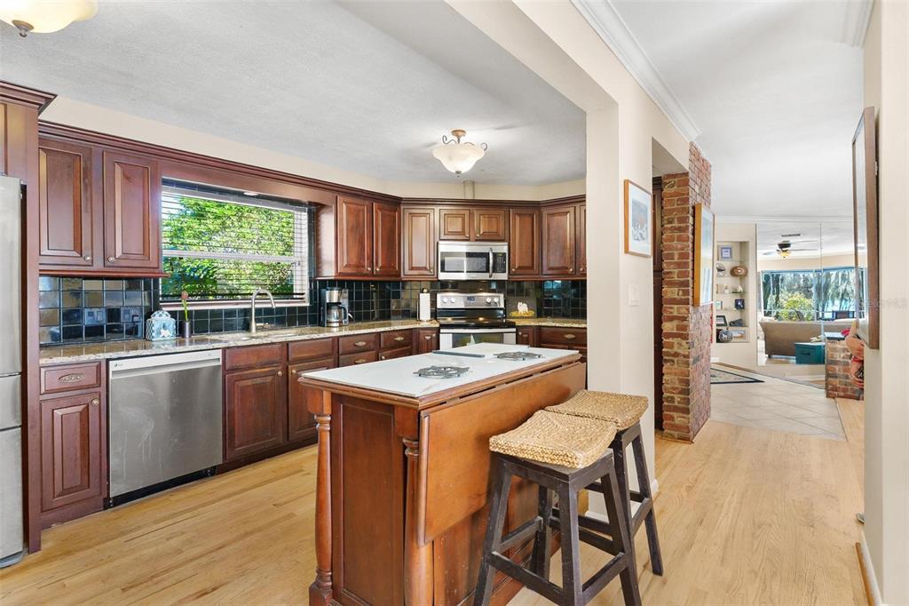 475 Guerrant Street Umatilla, FL 32784 - Photo 17 of 63 a kitchen with a stove a sink a refrigerator and a wooden cabinets