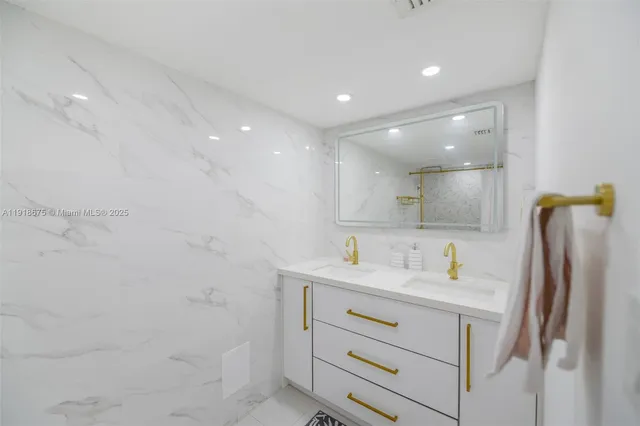 a bathroom with a sink a shower a mirror and a toilet