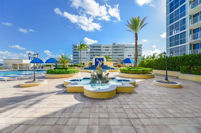 a view of a patio with dining table and chairs potted plants and a fountain