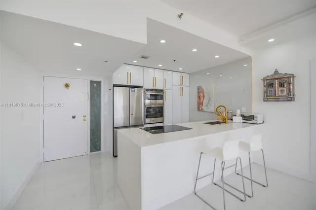 a kitchen with stainless steel appliances granite countertop a refrigerator and a stove top oven
