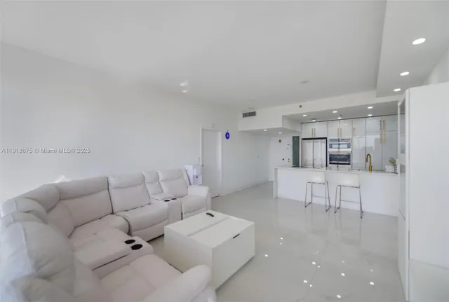 a living room with furniture and view of kitchen
