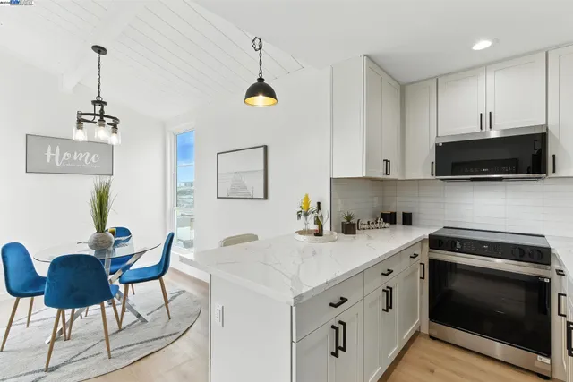 a kitchen with stainless steel appliances granite countertop a sink a stove a microwave a refrigerator and cabinets