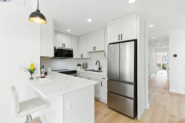 a kitchen with stainless steel appliances a refrigerator sink and microwave