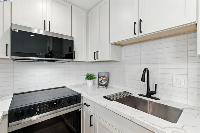 a kitchen with a sink a stove and cabinets