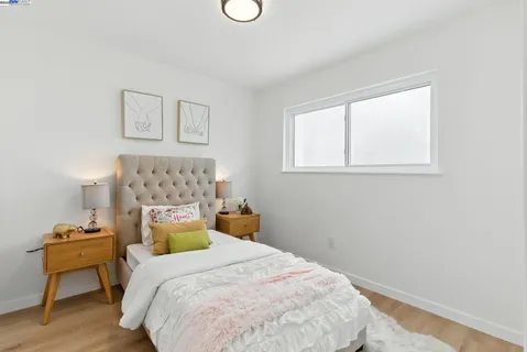 a bedroom with a bed and wooden floor