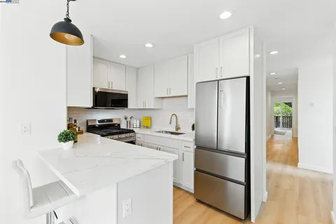 a view of a dining room with furniture a kitchen and chandelier