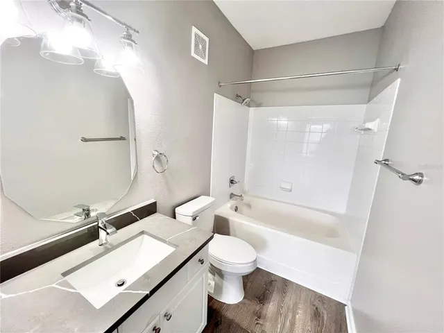 a bathroom with a sink mirror toilet and bathtub