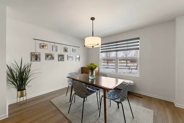 a dining room with furniture potted plants and wooden floor