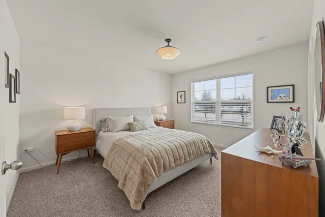 a bedroom with a bed and a table in it with window