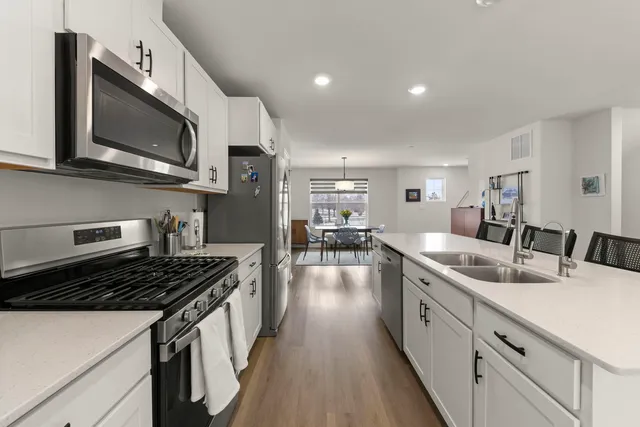 a kitchen with stainless steel appliances granite countertop a sink stove and microwave