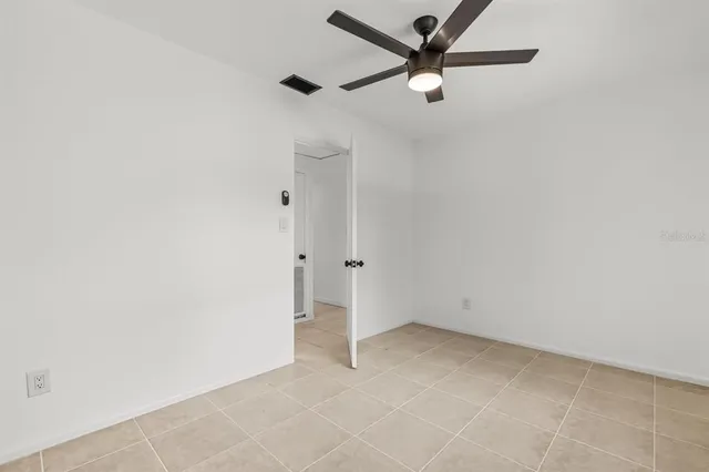 an empty room with a ceiling fan and carpet