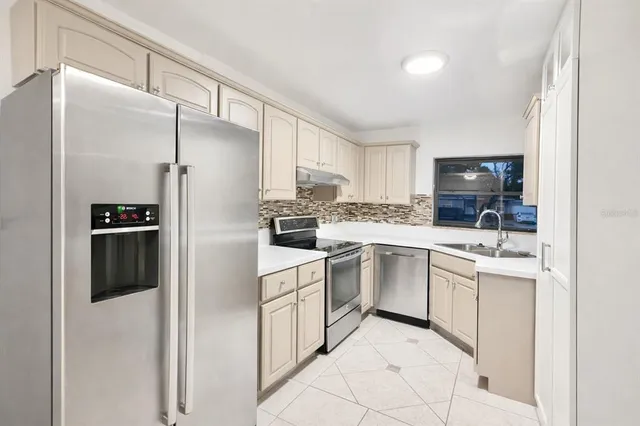 a kitchen with white cabinets and white appliances