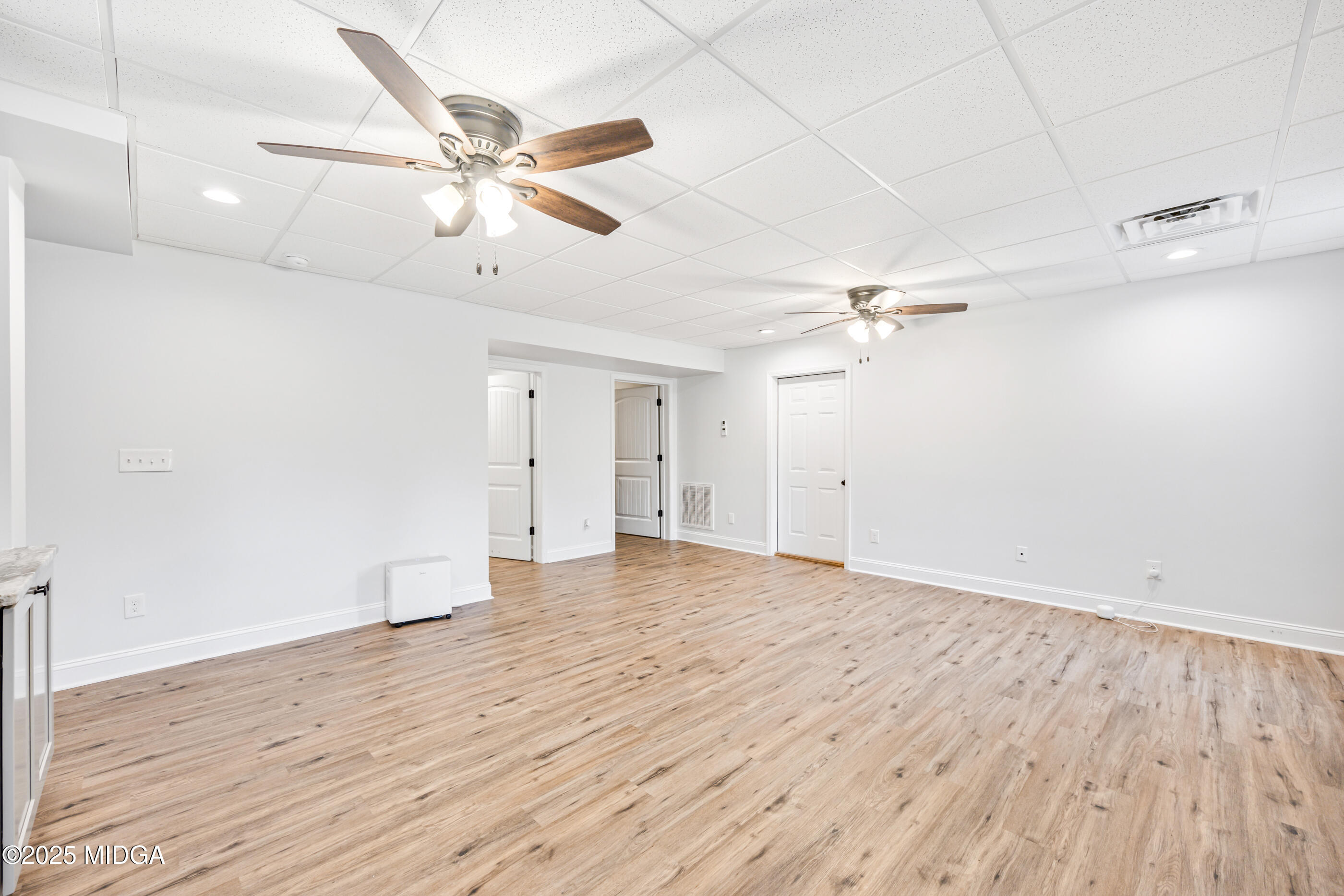 36 River Rapids Drive Forsyth, GA 31029 - Photo 31 of 57 an empty room with wooden floor ceiling fan and windows
