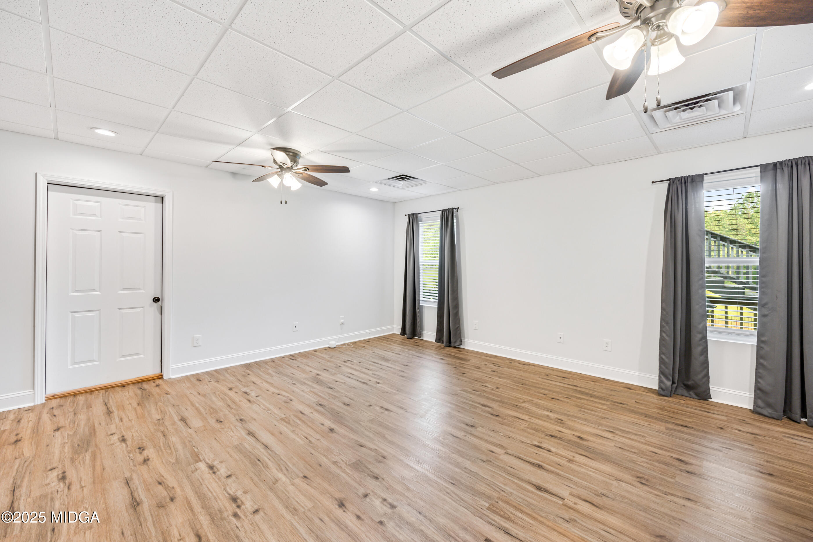 36 River Rapids Drive Forsyth, GA 31029 - Photo 32 of 57 a view of an empty room with window and wooden floor