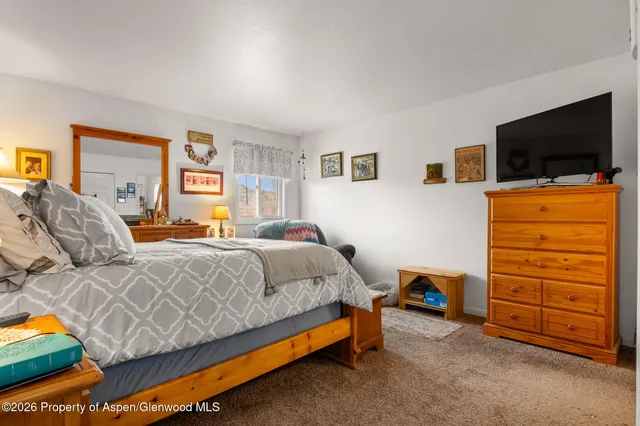 a bedroom with furniture and a flat screen tv