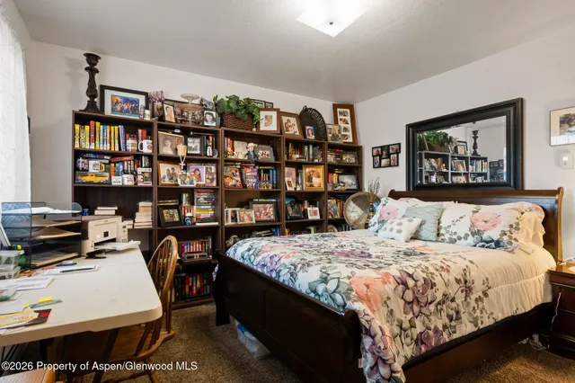 a bedroom with a bed a book shelf and a book shelf
