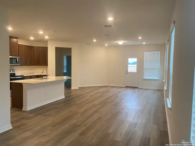 a view of kitchen with wooden floor and electronic appliances