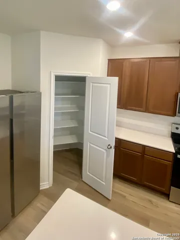 a kitchen with cabinets and a refrigerator