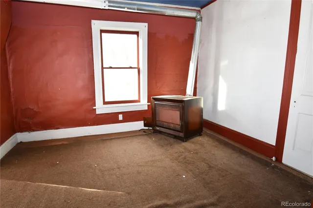 a view of a room with wooden floor and a window