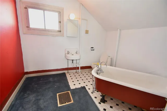 an empty room with chandelier fan and windows