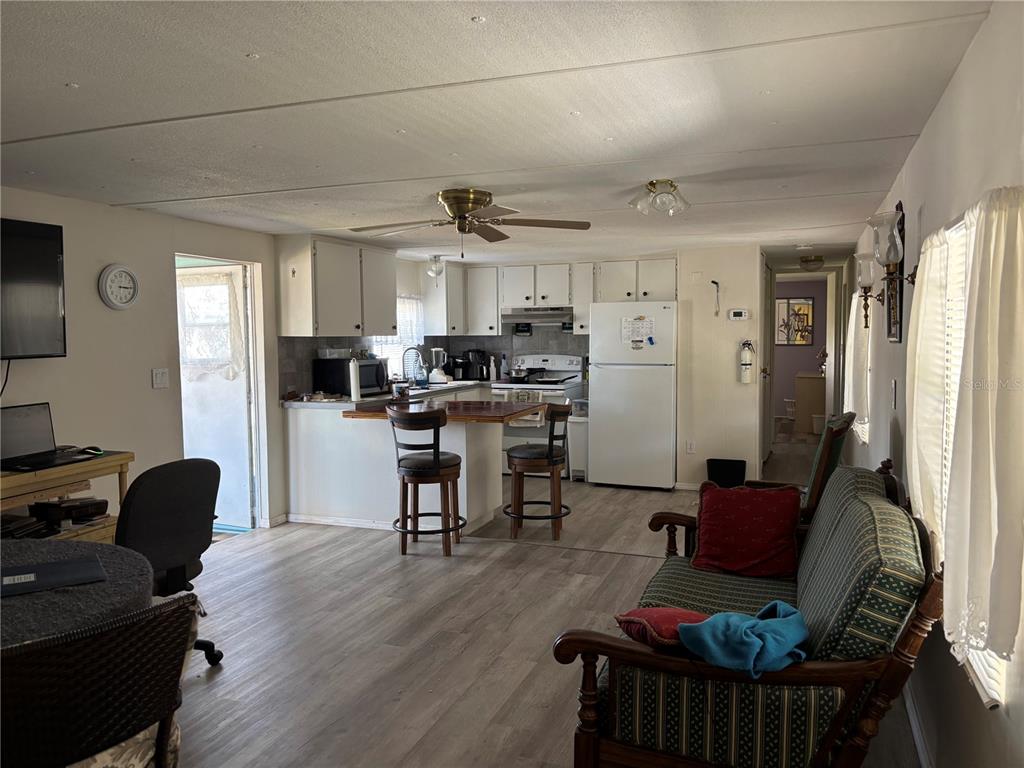 3346 Chatford Drive Holiday, FL 34690 - Photo 3 of 10 a living room with stainless steel appliances furniture a dining table wooden floor and a window