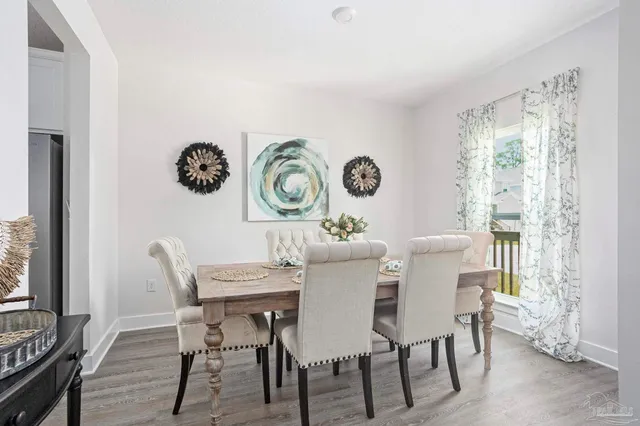 a view of a dining room and livingroom with furniture window and wooden floor