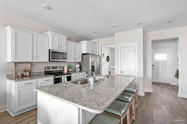 a kitchen with stainless steel appliances granite countertop a sink refrigerator and cabinets