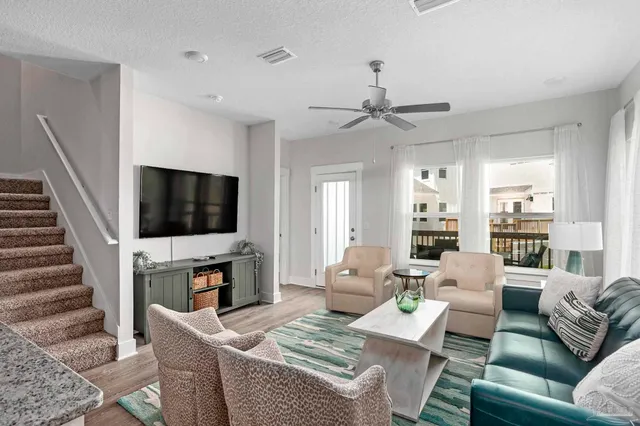 a living room with furniture a flat screen tv and a fireplace