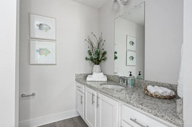 a bathroom with a granite countertop sink a mirror and vanity