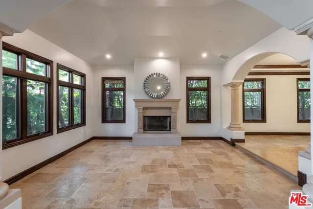 a view of an empty room with a fireplace and a window