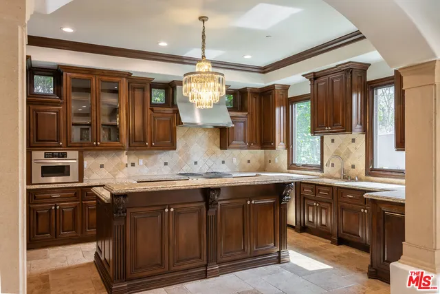 a large kitchen with a sink and stainless steel appliances