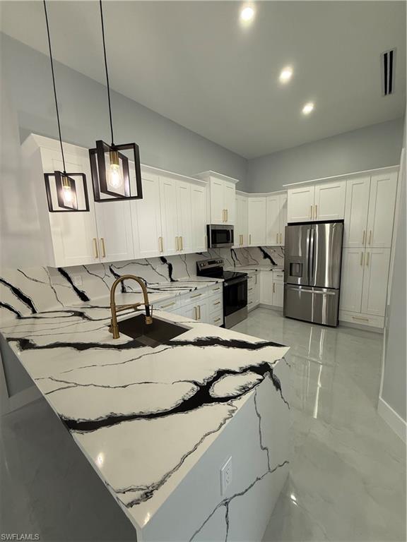 4353 22nd Avenue Northeast Naples, FL 34120 - Photo 11 of 18 a view of kitchen center island cabinets and stainless steel appliances