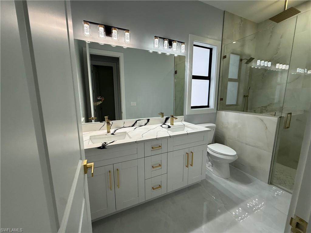 4353 22nd Avenue Northeast Naples, FL 34120 - Photo 6 of 18 a bathroom with a double vanity sink toilet and shower