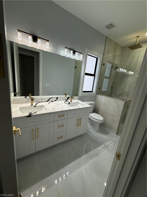 4353 22nd Avenue Northeast Naples, FL 34120 - Photo 8 of 18 a bathroom with a double vanity sink mirror and toilet