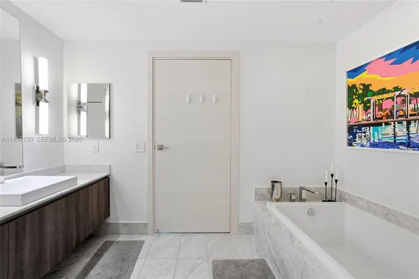 a bathroom with a tub sink and mirror