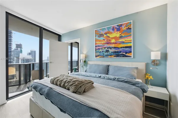 a bedroom with a bed and a painting on the wall