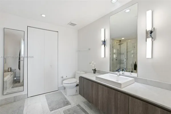 a bathroom with a double vanity sink toilet and shower