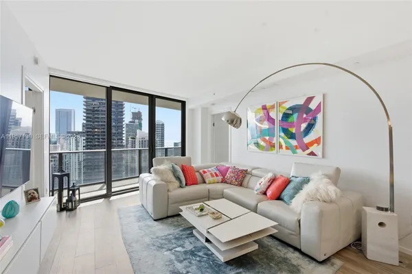 a living room with furniture and a floor to ceiling window
