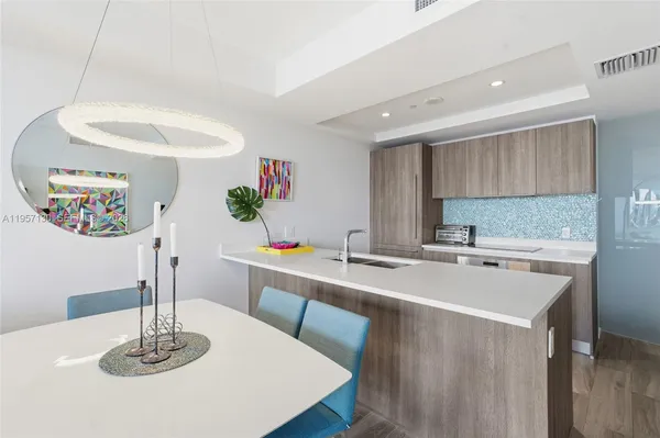 a kitchen with stainless steel appliances granite countertop a sink and a refrigerator
