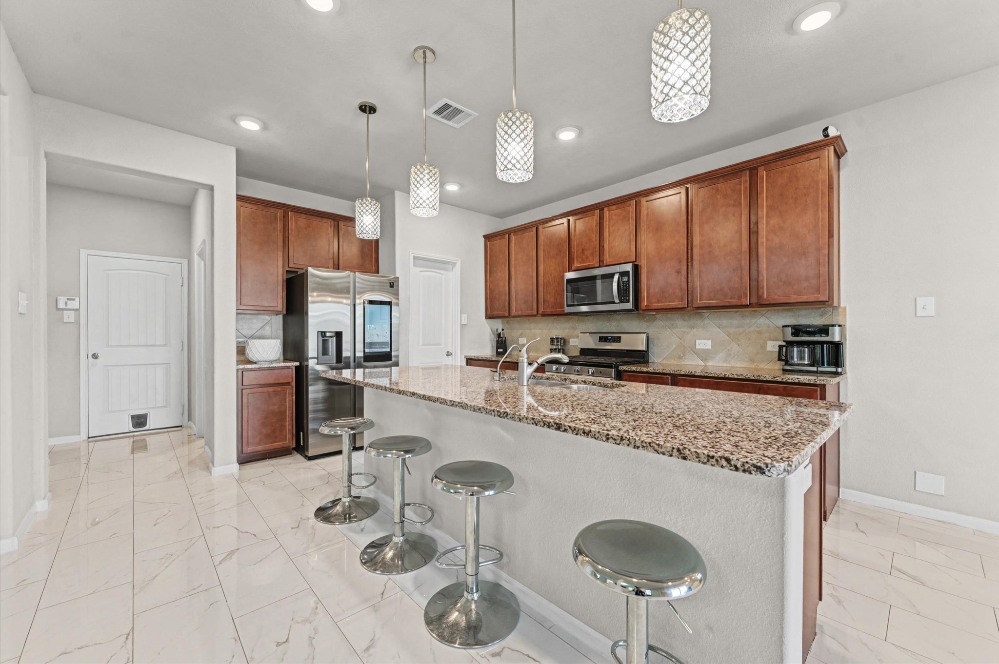 21610 Lemon Beebrush Lane Katy, TX 77449 - Photo 9 of 25 a kitchen with stainless steel appliances granite countertop a sink a stove a refrigerator cabinets and chairs
