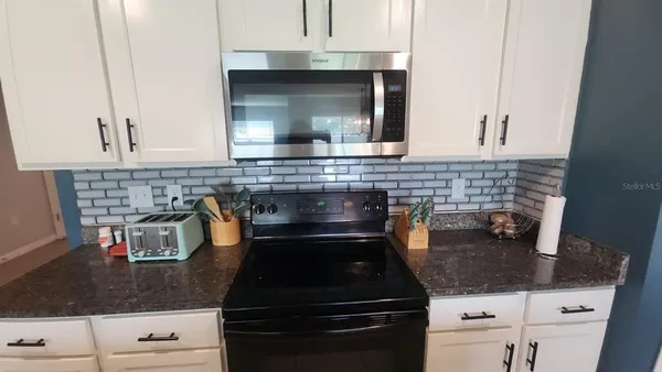 a kitchen with granite countertop a stove and a sink