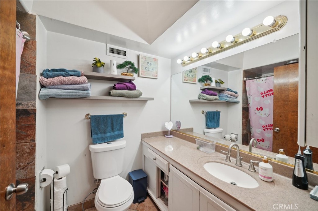 6769 Sunset Circle Riverside, CA 92505 - Photo 28 of 54 a bathroom with a granite countertop sink mirror vanity and toilet